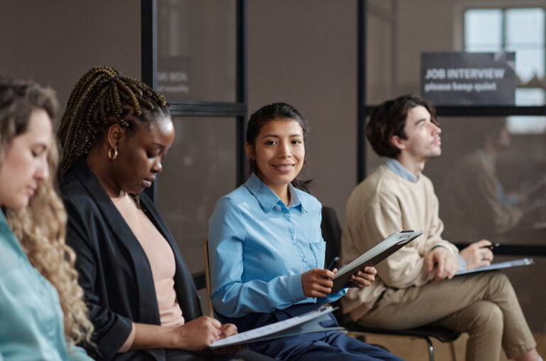 Applicants waiting confidently for entry-level jobs in a modern office interview setting.
